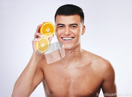 Image of Skincare, orange and wellness with portrait of man in studio for health, detox and natural cosmetics. Vitamin c, nutrition and summer with face of person and fruit on white background for self care