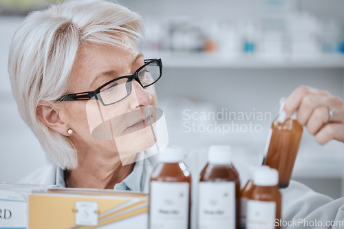 Image of Senior woman, pharmacist and inventory inspection, medicine or checking stock on shelf at drugstore. Mature female person, medical or healthcare employee reading pharmaceutical product at pharmacy