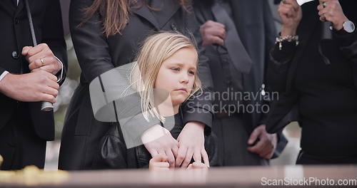 Image of Child, sad and family at funeral at graveyard ceremony outdoor at burial place. Death, grief and group of people with casket or coffin at cemetery for service while mourning a loss at event or grave