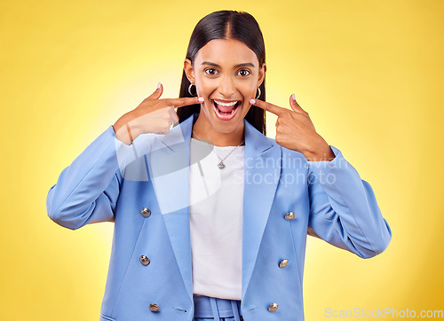 Image of Fingers on cheek, portrait and a happy woman in studio for positive attitude, dimples and emoji. Indian model person or student with fashion, comic and excited face or silly mood on yellow background