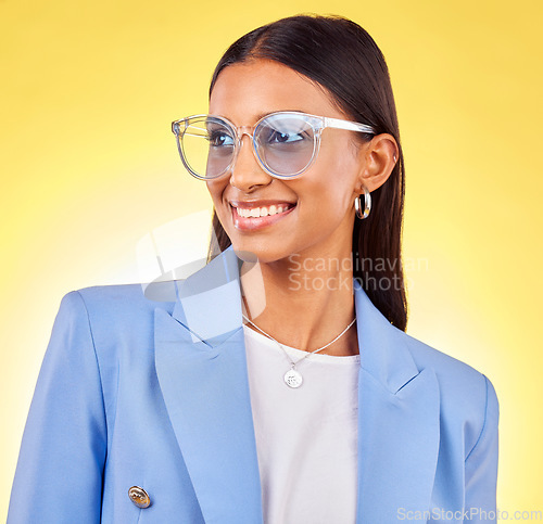 Image of Young business woman, sunglasses and studio with thinking, vision and smile by yellow background. Entrepreneur, fashion model and happy with stylish frame, lens and trendy suit with ideas for beauty