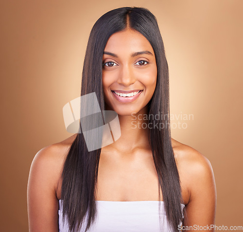 Image of Portrait, hair care and woman with a smile, shine and skincare on a brown studio background. Face, person and model with happiness, aesthetic or glow with healthy skin, texture and volume with beauty