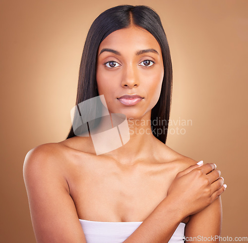 Image of Portrait, hair care and woman with dermatology, skincare and volume on a brown studio background. Face, person and model with natural beauty, aesthetic and glow with healthy skin, texture and shine