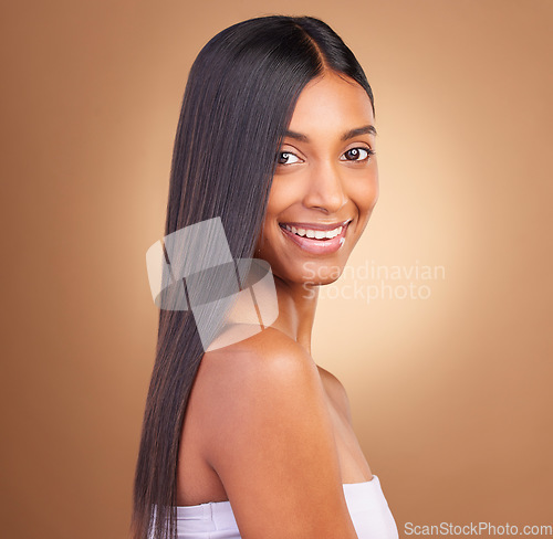 Image of Portrait, hair care and woman with a smile, cosmetics and skincare on a brown studio background. Face, person and model with natural beauty, aesthetic and glow with dermatology, texture and volume