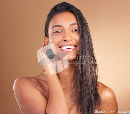 Image of Beauty, portrait and woman in studio for hair, growth or texture and shine against a brown background space. Haircare, cosmetics and face of female model with smile for shampoo or mask results