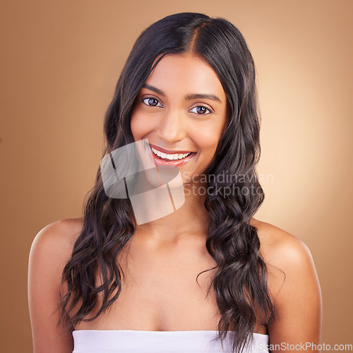 Image of Portrait, hair care and woman with dermatology, cosmetics and skincare on a brown studio background. Face, person and model with happiness, aesthetic and glow with texture, volume and natural beauty