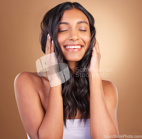 Image of Portrait, hair care and woman with a smile, volume and wellness on a brown studio background. Face, person and model with shine, texture and aesthetic with dermatology, shampoo or cosmetics with glow