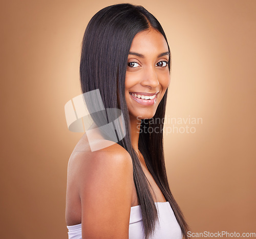 Image of Portrait, hair care and woman with glow, shine and texture with volume on a brown studio background. Face, person or model with cosmetics, aesthetic or dermatology with healthy skin or natural beauty