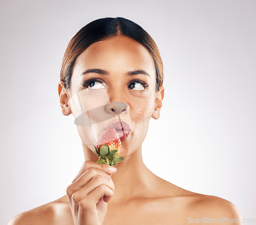Image of Skincare, kiss and woman with strawberry in studio for wellness, nutrition or natural cosmetics on white background. Beauty, face and female model with fruit for antioxidants or anti aging fine lines