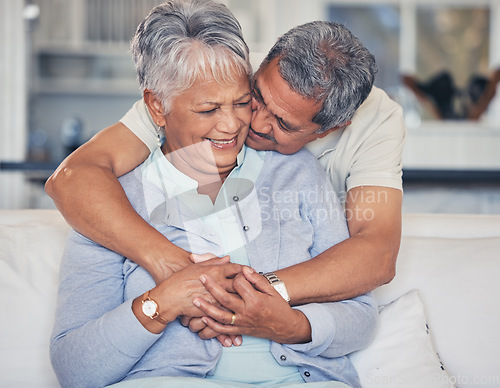 Image of Love, hug and a senior couple on a sofa in the living room of their home together during retirement. Support, relax and a elderly man embracing his pensioner wife in a house for relationship bonding