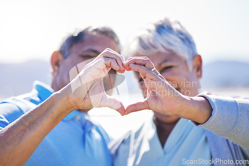 Image of Heart, hands and senior couple at a beach with love, care and trust while bonding in nature together. Emoji, finger and old people with thank you, support or sign of kindness, hope or freedom at sea