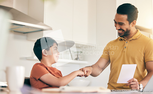 Image of Fist bump, homework and father with child at their home in celebration of completed studying. Happy, smile and young dad bonding together with his boy kid in the kitchen of modern house or apartment.