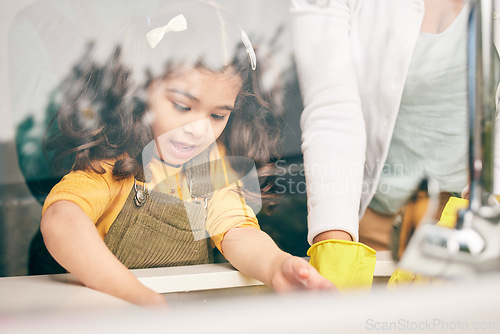 Image of Girl, learning and washing dishes with mom in kitchen, help or show skills in house for development. Cleaning, mother and daughter by sink, hygiene or teaching with support, bacteria or dirt in home