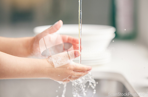 Image of Child, washing hands and kitchen with foam in closeup for health, safety and stop bacteria in house. Kid, cleaning palm and soap with water, liquid or learning in bathroom for wellness in family home