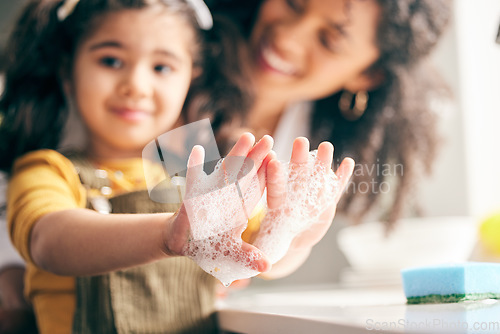 Image of Soap, cleaning hands and family with child in bathroom for learning healthy hygiene routine at home. Closeup, mom and girl kid washing palm with foam for safety of bacteria, dirt or germs on skincare