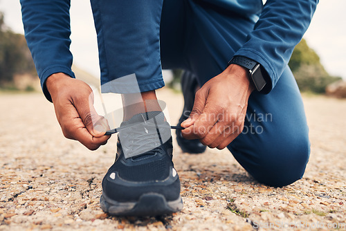 Image of Tying laces, fitness and hands of a person for running, cardio or training preparation in nature. Closeup, ground and a runner or athlete with shoes and feet to start a race, marathon or a workout