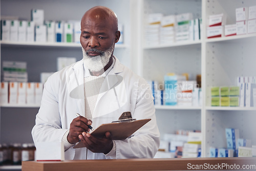 Image of Pharmacy, clipboard and mature black man writing notes of product description, medical drugs information or clinic stock take. List, pills and African pharmacist doing store inventory of supplements