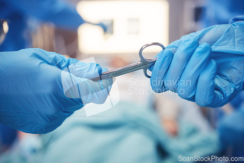 Image of Hands, scissors for operation and teamwork in the hospital during surgery or emergency medical procedure. Collaboration, healthcare equipment and doctors in theatre together to save a patient closeup