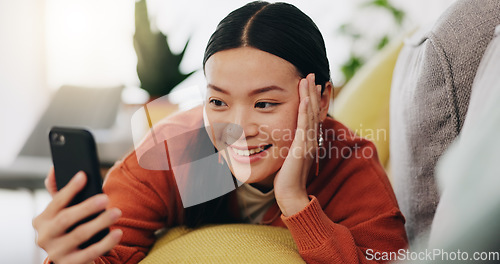 Image of Asian woman, selfie and lying on sofa with hand on face and love for profile picture, vlog or social media at home. Happy female relaxing with smile and hand signs for photo or online vlogging on cou