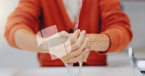 Image of Washing hands, water and cleaning at sink in bathroom for hygiene, wellness or health. Skincare, liquid and woman clean hand to remove bacteria, germs and dirt, sanitary and disinfection in home.