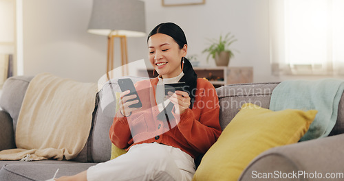 Image of Happy woman, credit card and phone on couch online shopping, ecommerce and fintech easy payment. Asian person in China typing bank information on cellphone for discount or finance transaction at home
