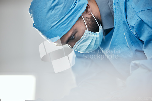Image of Healthcare, face mask and a doctor in a theater for surgery, medical consulting or a solution. Serious, thinking and a man or male surgeon working on an emergency cardiology check or inspection