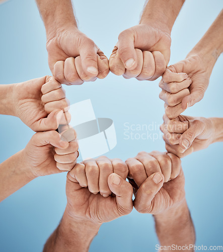 Image of People, hands together and fist bump in teamwork, unity or community below blue sky background. Low angle, closeup or group goals in team building, motivation or support in trust on mockup space