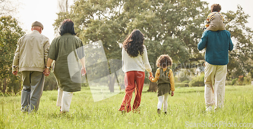 Image of Love, holding hands and relax with big family in park for bonding, support and summer. Vacation, happy and holiday with people walking in grass field in nature for peace, generations or care together