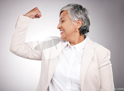 Image of Strong, smile and mature businesswoman in a studio with strength, feminism or confidence gesture. Happy, empowerment and female model from Mexico flexing her arm muscles for emoji by gray background.