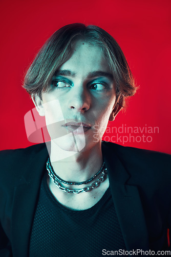 Image of Fashion, thinking and gay man in makeup at studio isolated on a red background. Cosmetics, lgbtq style and male model in cool clothes, aesthetic and serious idea for queer or non binary