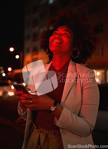 Image of Thinking, woman and phone in city at night, typing and social media outdoor. Idea, smartphone and African person in street on internet, networking and happy smile on website app on neon light bokeh