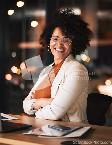Image of Night, portrait and a black woman with arms crossed at work for business pride or a deadline. Desk, happy and an African employee with confidence during overtime and late shift in the office