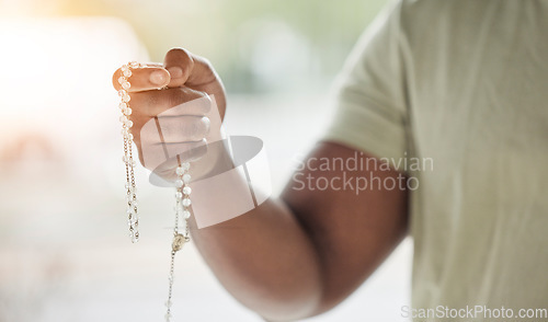 Image of Rosary, man hand and faith with prayer beads in home with hope, christian praise and religion. Praying, necklace and worship in house with hope, gratitude and spiritual guide for support and healing