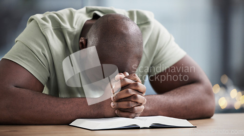 Image of Bible, praying and man with book and religion study at home for worship and spiritual support. Faith, christian knowledge and person with gratitude, scripture education and hope for guidance in house