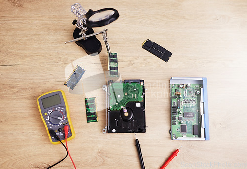 Image of Motherboard, engineering and electrical hardware for maintenance, repair or fixing with equipment. IT, circuit developer and top view of a dashboard microchip with tools for an update on a wood table