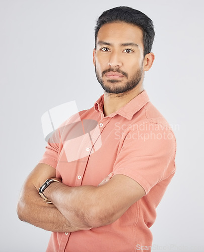 Image of Portrait, confident and arms crossed with a serious asian man in studio on gray background. Fashion, mindset and pride with a young model posing in a pink shirt for trendy clothes style in Japan