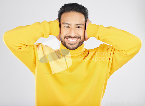 Image of Portrait, smile and man cover ears in studio isolated on a white background. Face, noise and happy Asian person not listening, hearing loud sound and silence for peace, quiet and ignore to relax.