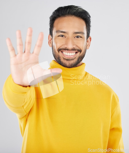Image of Man, palm and stop in studio portrait, smile and emoji for opinion, rejection or no by white background. Young Indian guy, student or fashion model with hand, sign language or show gesture for review