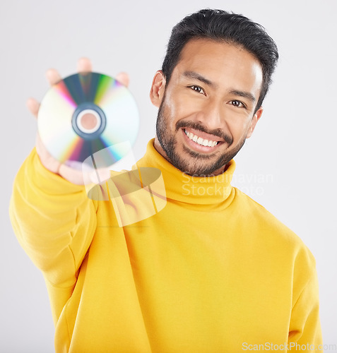 Image of Man, cd and smile in studio portrait for music, tech or software for data, info or sound by white background. Student guy, happy model and retro disk storage or dvd for film, multimedia or movie