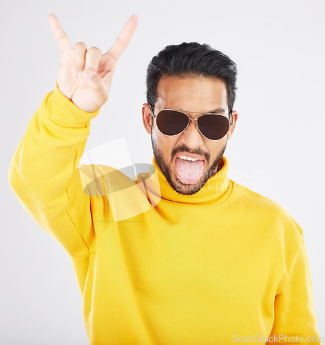Image of Man, horns and hand with sunglasses, studio portrait and rock icon for gesture, clothes and white background. Young guy, model and devil fingers for attitude, fashion and sign with emoji for culture