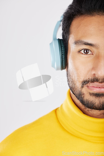 Image of Half portrait, man and headphones on a white background for a podcast, music or streaming radio. Serious, face and an Asian person listening to sound, audio or a track isolated on a studio backdrop