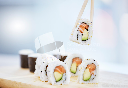 Image of Sushi, closeup and food with fish for eating, salmon and rice with avocado, healthy and fine dining. Japanese cuisine, catering with lunch or dinner meal, chopsticks and gourmet seafood for nutrition