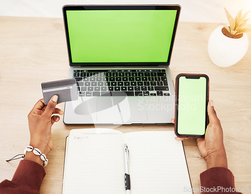 Image of Woman, hands and laptop with phone green screen mockup and credit card in online shopping or banking at office. Female person with debit on computer or smartphone app display in ecommerce or fintech