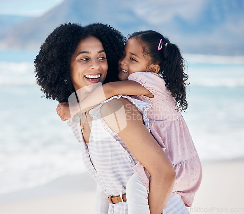Image of Happy, piggyback and mother with child at the beach on a family vacation, adventure or holiday. Smile, love and young mom carrying, playing and bonding with her girl kid by the ocean on weekend trip.