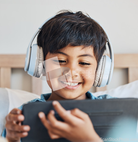 Image of Face of kid, headphones and tablet in home for reading ebook, watch movies and play video game on elearning app. Happy boy child, digital tech and listening to multimedia, music and streaming cartoon