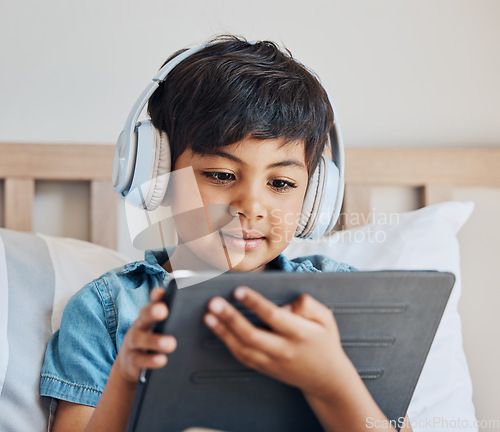 Image of Face of boy, headphones and tablet in home for reading ebook, watch cartoon and play video games on elearning app. Child, kid and listening to multimedia, music and streaming movies on digital tech