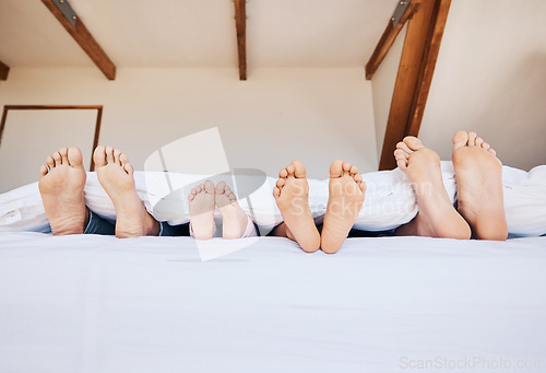 Image of Family, morning and feet in bed to relax together closeup in their home on the weekend with mockup. Mother, father and kids in the bedroom on mattress while on holiday or vacation in their apartment