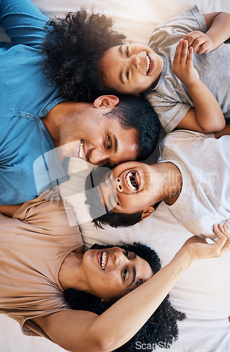 Image of Above, laughing and portrait of a family on the bed for bonding, love and comic conversation. Together, house and parents with children for talking, jokes or funny communication in the bedroom