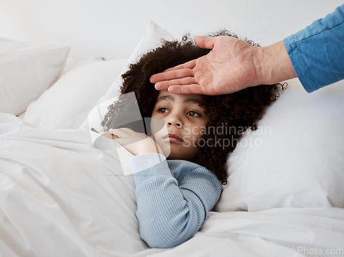 Image of Sick, child and hand on head check for temperature, fever and disease in a bed with headache. Bedroom, tired and fatigue of a young kid with healthcare and flu problem with parent support and monitor