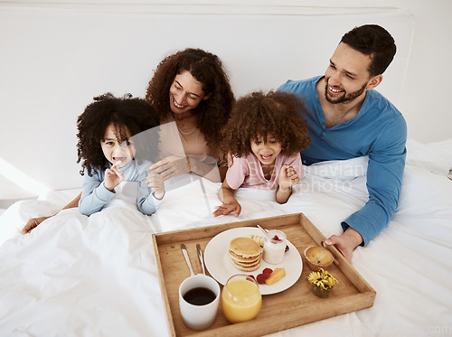 Image of Parents, kids and breakfast in bed, morning or excited for love, bonding or care on holiday. Mother, papa and children in bedroom, food and smile together for nutrition, eating and happy family home